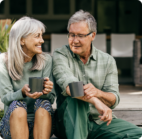 Image of older couple sitting together drinking coffee outdoors