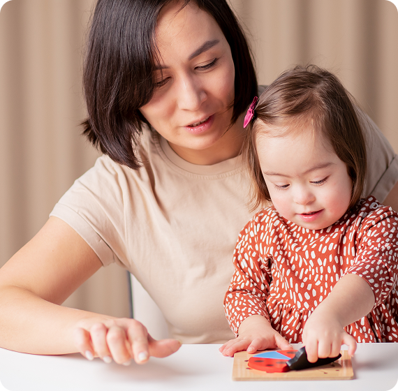 Image of parent helping a young child play with a wooden puzzle at a table.