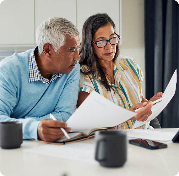 Image of couple reviewing documents together at a kitchen table.