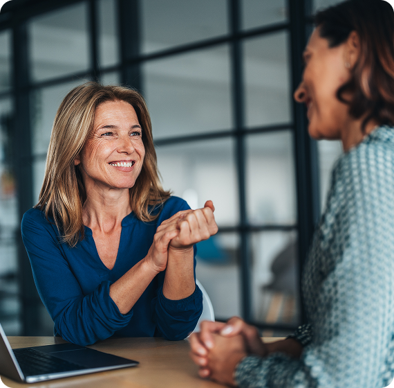  Image of a financial advisor smiling and talking with a client during a meeting.