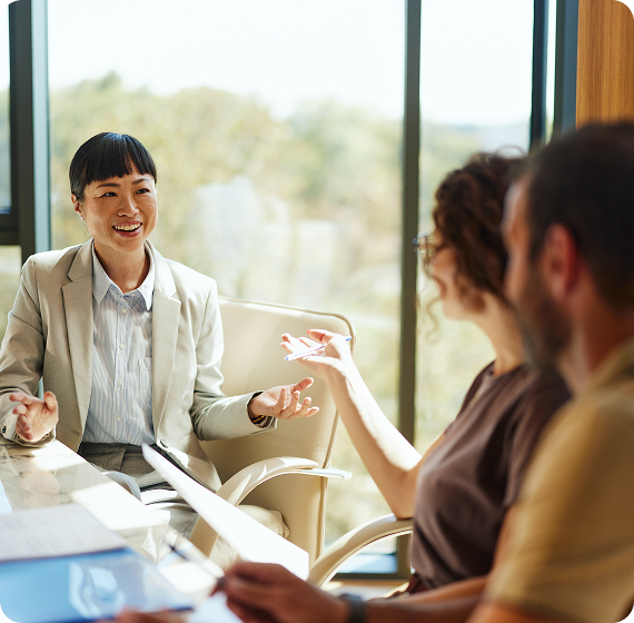 Image of financial advisor leading a friendly discussion with clients around a table.