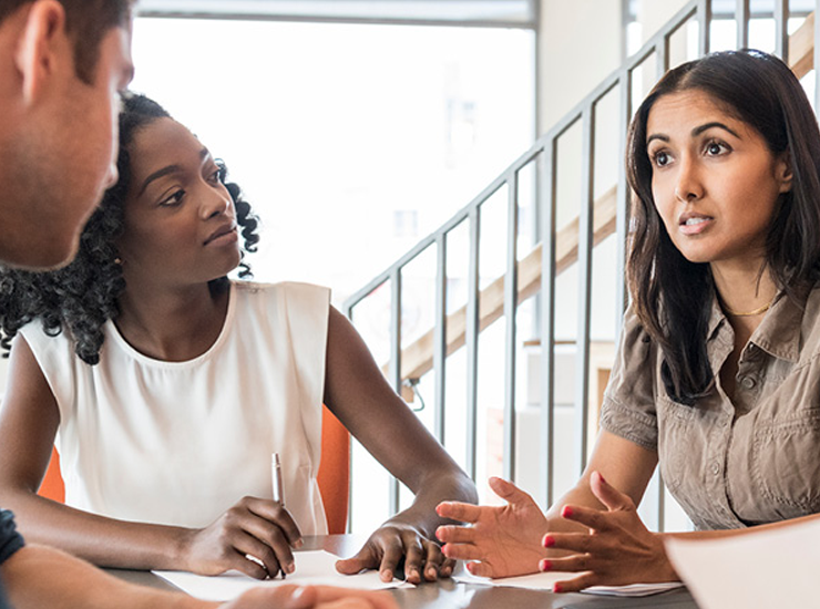 Three people discuss ideas.